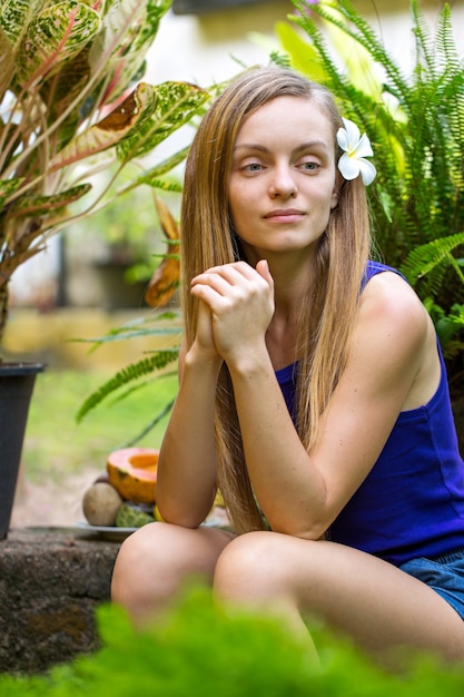 Foto mulher jovem no jardim com plantas tropicais