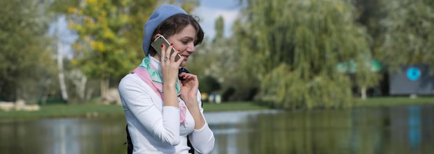 Mulher jovem no parque falando ao telefone celular. retrato de uma linda garota no estilo francês