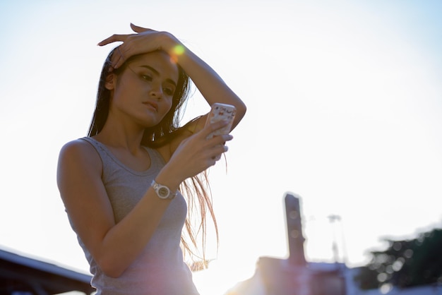 Foto mulher jovem olhando para a câmera contra o céu