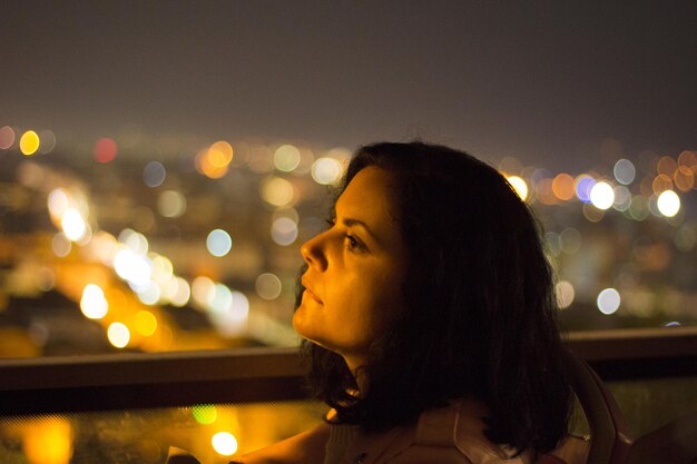 Foto mulher jovem olhando para longe à noite