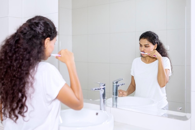 Foto mulher jovem olhando para longe enquanto está sentada na casa de banho