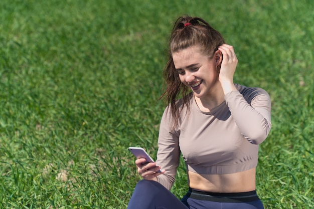 Mulher jovem olhando para o telefone no campo