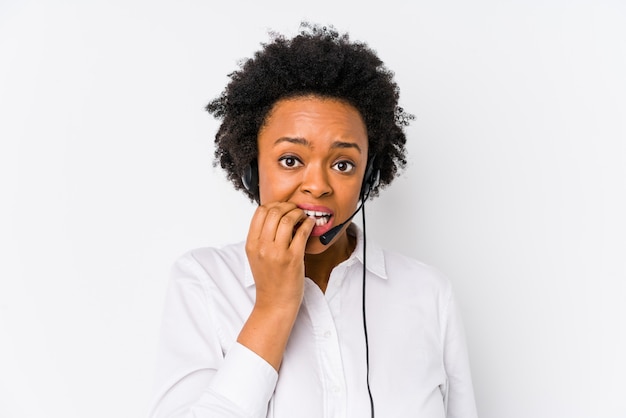 Mulher jovem operador de telemarketing americano africano isolado roer unhas, nervoso e muito ansioso.