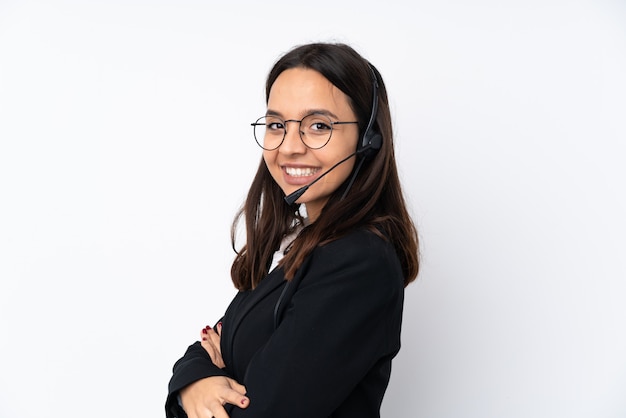 Mulher jovem operador de telemarketing na parede branca com os braços cruzados e olhando para a frente