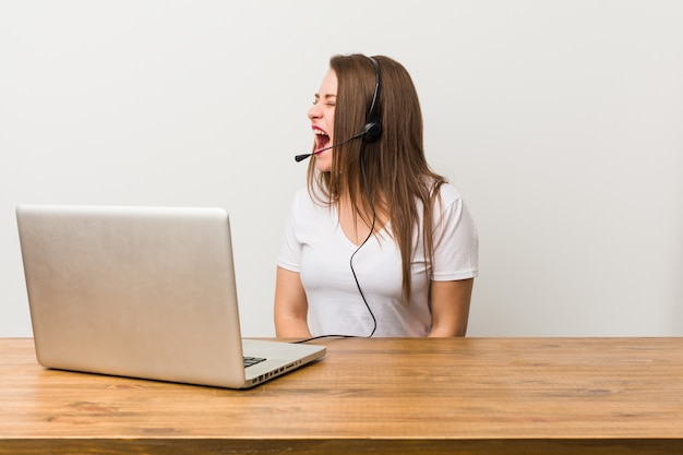 Mulher jovem operador de telemarketing shoutingwards um copyspace