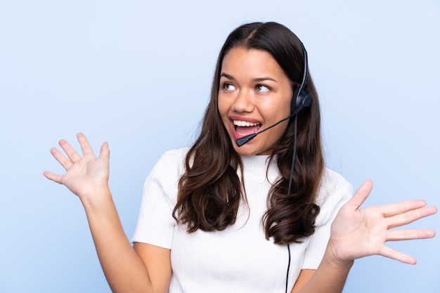 Mulher jovem operador de telemarketing sobre parede isolada