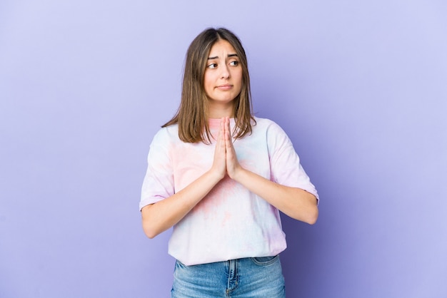 Mulher jovem orando, demonstrando devoção, pessoa religiosa em busca de inspiração divina