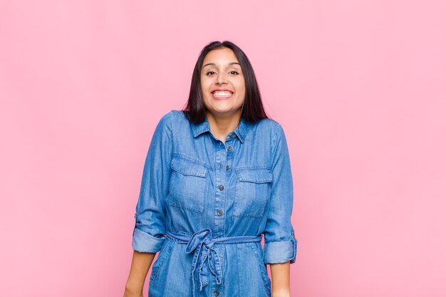 Mulher jovem parecendo feliz e boba com um sorriso largo, divertido e maluco e olhos bem abertos