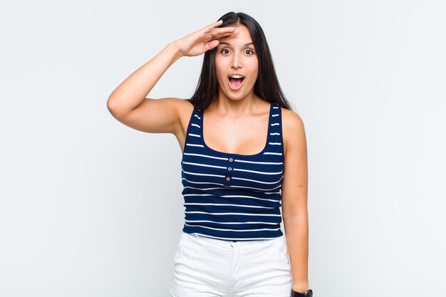 Mulher jovem parecendo feliz, espantada e surpresa, sorrindo e percebendo uma boa notícia incrível