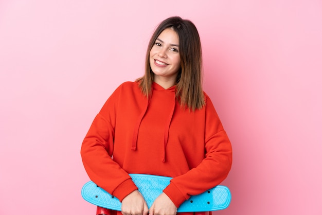 Mulher jovem patinadora sobre parede rosa isolada