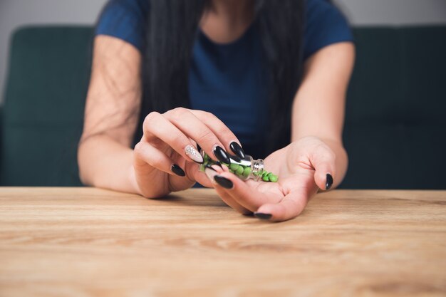 Mulher jovem pega comprimidos de um recipiente para as mãos