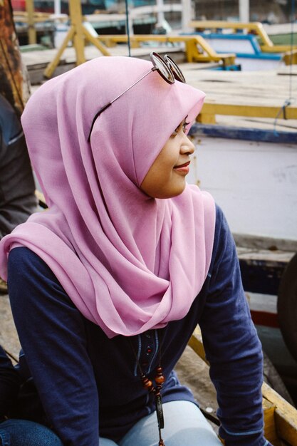 Foto mulher jovem pensativa usando hijab enquanto está sentada em um barco
