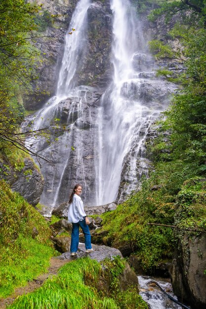 Mulher jovem perto de uma cachoeira na cidade de San Pietro, na Itália