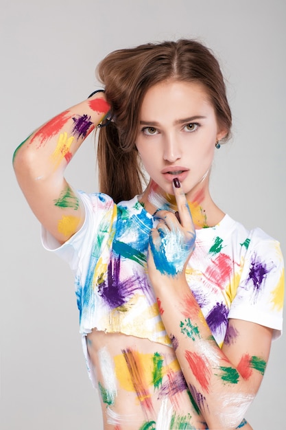 Mulher jovem pintada com tinta multicolorida