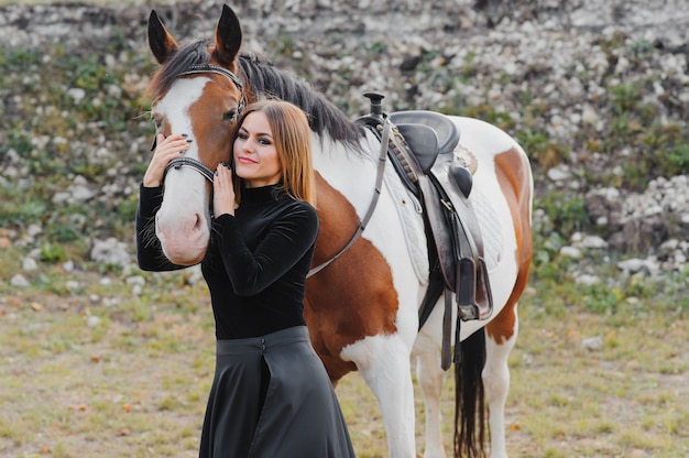 Mulher jovem posando com um cavalo