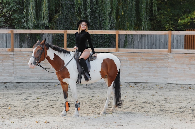 Mulher jovem posando com um cavalo