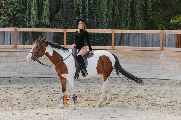 Mulher jovem posando com um cavalo