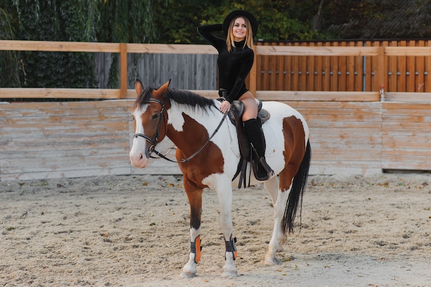 Mulher jovem posando com um cavalo