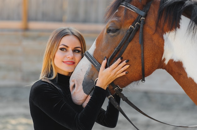 Mulher jovem posando com um cavalo