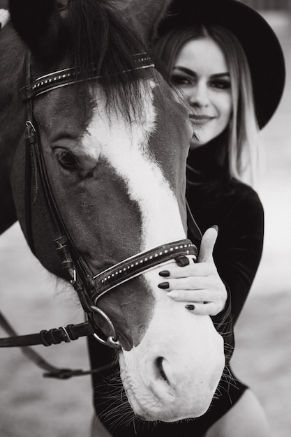 Mulher jovem posando com um cavalo