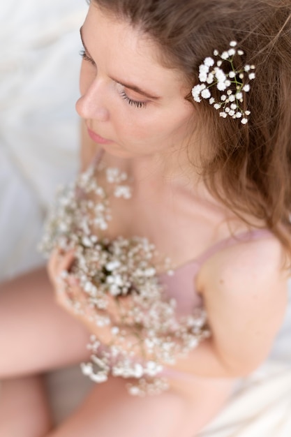 Mulher jovem posando confiante em lingerie com flores