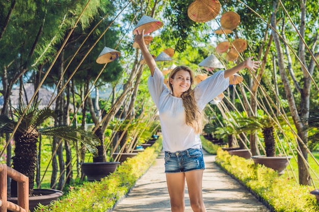 Mulher jovem posando em um parque tropical