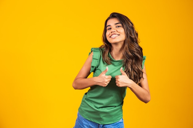 Mulher jovem positiva e feliz com o polegar para cima.