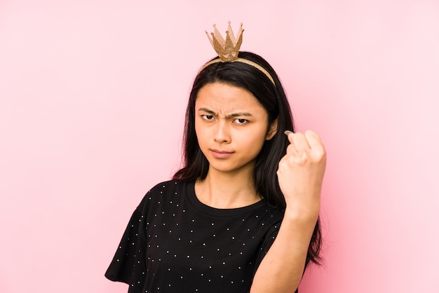 Mulher jovem princesa chinesa em uma parede rosa rindo e se divertindo.