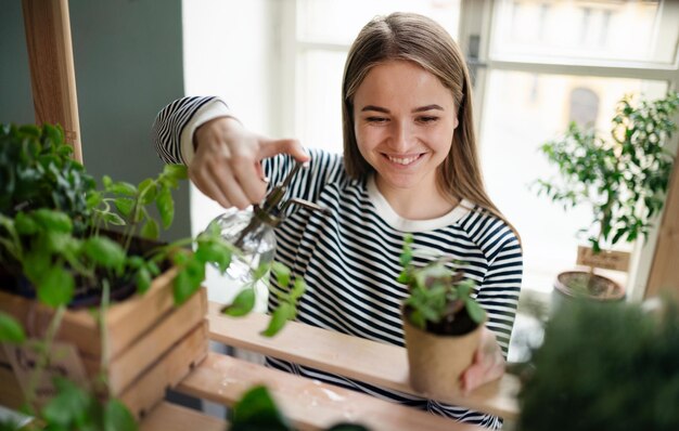 Mulher jovem que trabalha em casa, o conceito de cuidados com a planta. Conceito de coronavírus.