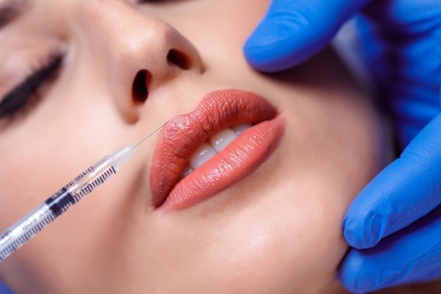 Mulher jovem recebe injeção de botox nos lábios. Mulher no salão de beleza. clínica de cirurgia plástica.