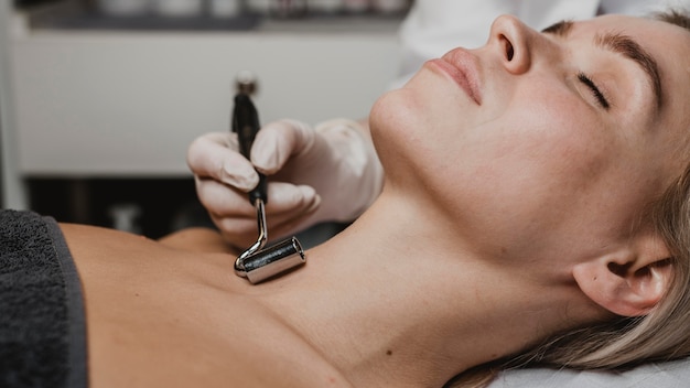 Foto mulher jovem recebendo tratamento facial e pescoço