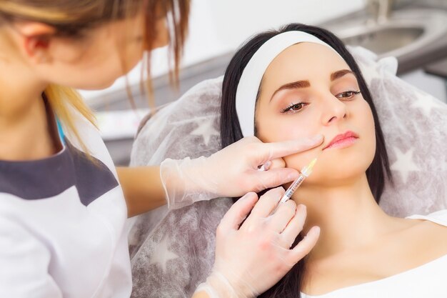 Foto mulher jovem recebendo uma injeção de ácido hialurônico