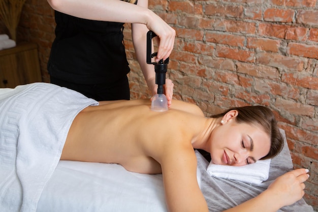 Foto mulher jovem recebendo uma massagem nas costas em um salão de spa conceito de tratamento de beleza