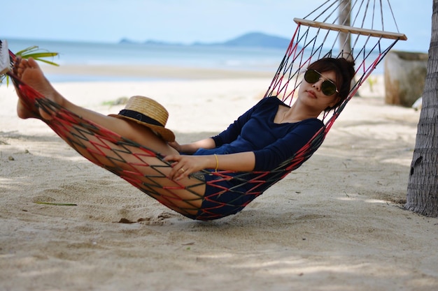 Mulher jovem relaxando em uma hamaca na praia