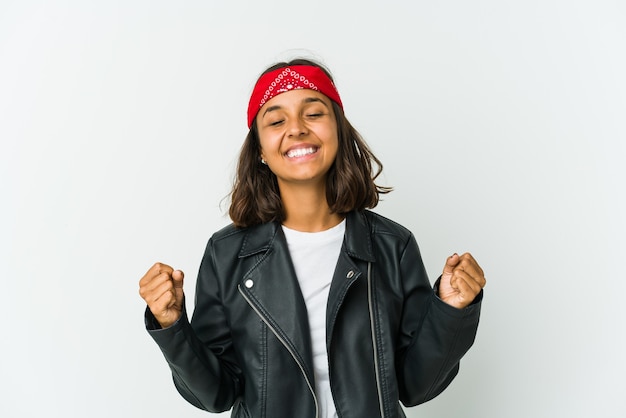 Mulher jovem roqueira latina isolada na parede branca, contemplando, planejando uma estratégia, pensando na forma de um negócio.