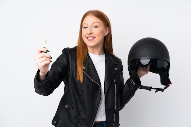 Foto mulher jovem ruiva com um capacete de moto sobre parede branca isolada