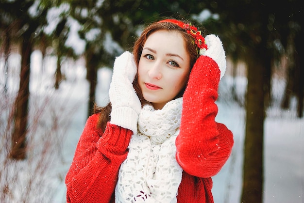 mulher jovem ruiva de camisola verde, vestido de noiva branco andando no parque de inverno gelado. Natal