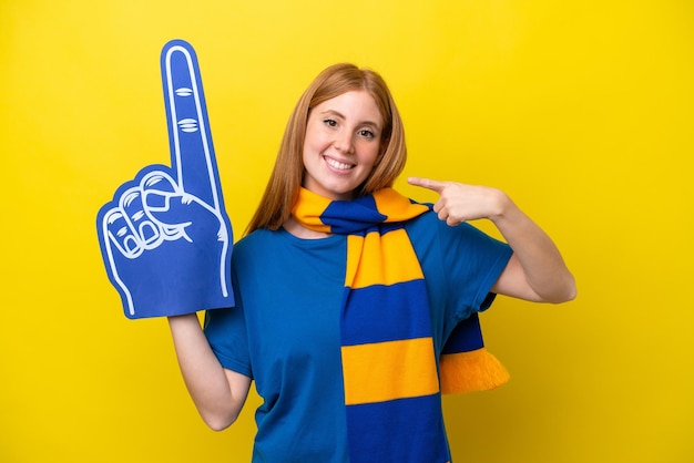 Mulher jovem ruiva fã de esportes isolada em fundo amarelo dando um polegar para cima gesto
