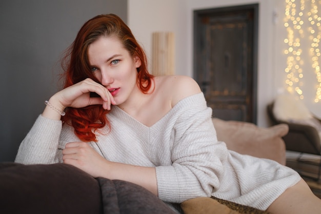Mulher jovem ruiva passando tempo livre em casa. Manhãs serenas. O conceito e a ideia de uma manhã tranquila, meditação e relaxamento em um dia de fim de semana