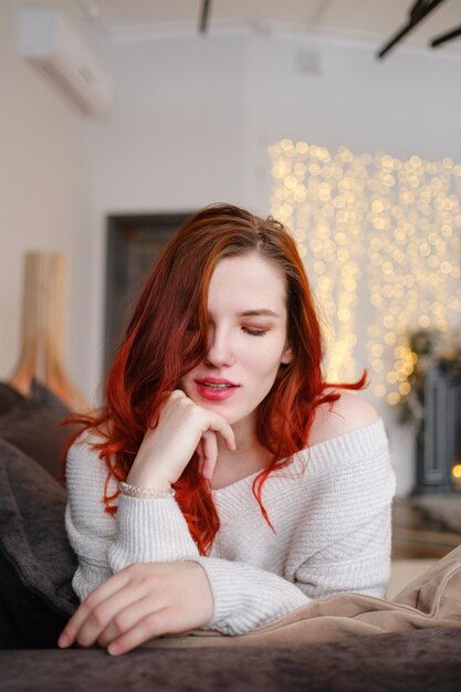 Mulher jovem ruiva passando tempo livre em casa. Manhãs serenas. O conceito e a ideia de uma manhã tranquila, meditação e relaxamento em um dia de fim de semana