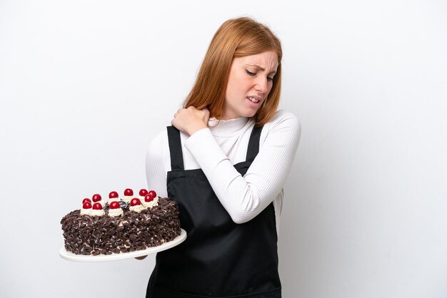 Foto mulher jovem ruiva segurando o bolo de aniversário isolado no fundo branco, sofrendo de dor no ombro por ter feito um esforço