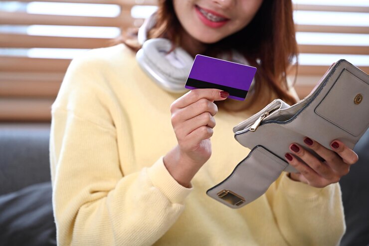 Foto mulher jovem satisfeita com cartão de crédito e carteira bancário pagamentos sem dinheiro e conceito de compras on-line
