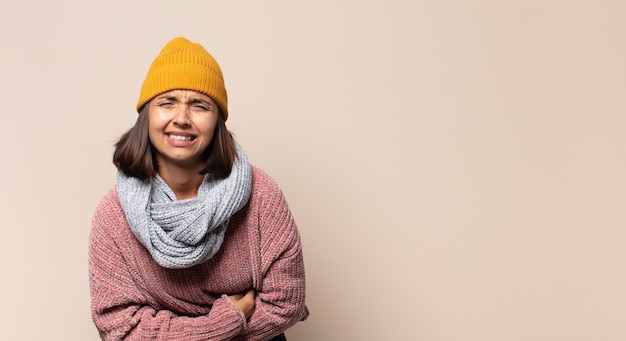 Mulher jovem se sentindo feliz, orgulhosa e esperançosa, pensando ou pensando, olhando para cima para copiar o espaço com os braços cruzados