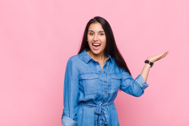 Mulher jovem se sentindo feliz, surpresa e alegre, sorrindo com atitude positiva, percebendo uma solução ou ideia