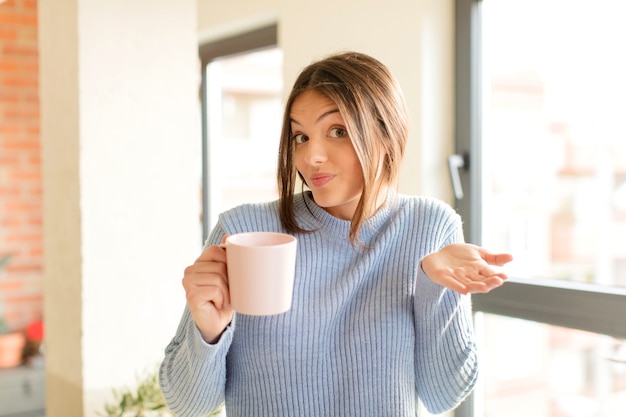 Mulher jovem se sentindo perplexa e confusa, duvidando de uma xícara de café