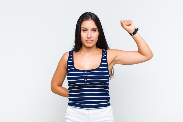 Mulher jovem se sentindo séria, forte e rebelde, levantando o punho, protestando ou lutando pela revolução