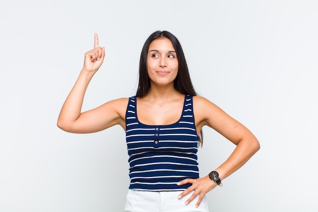 Mulher jovem se sentindo um gênio, segurando o dedo com orgulho no ar depois de perceber uma ótima ideia, dizendo eureka