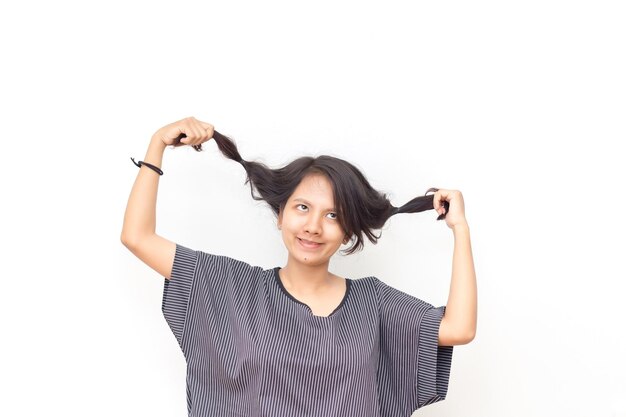 Foto mulher jovem segurando o cabelo enquanto está de pé contra um fundo branco