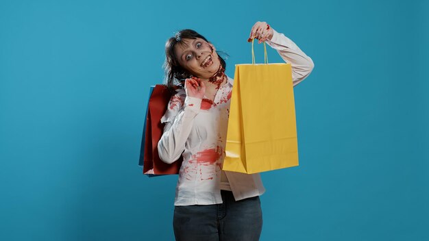 Foto mulher jovem segurando sacos de compras contra fundo azul