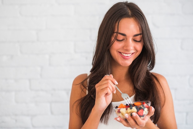 Foto mulher jovem, segurando, salada fruta, em, tigela vidro